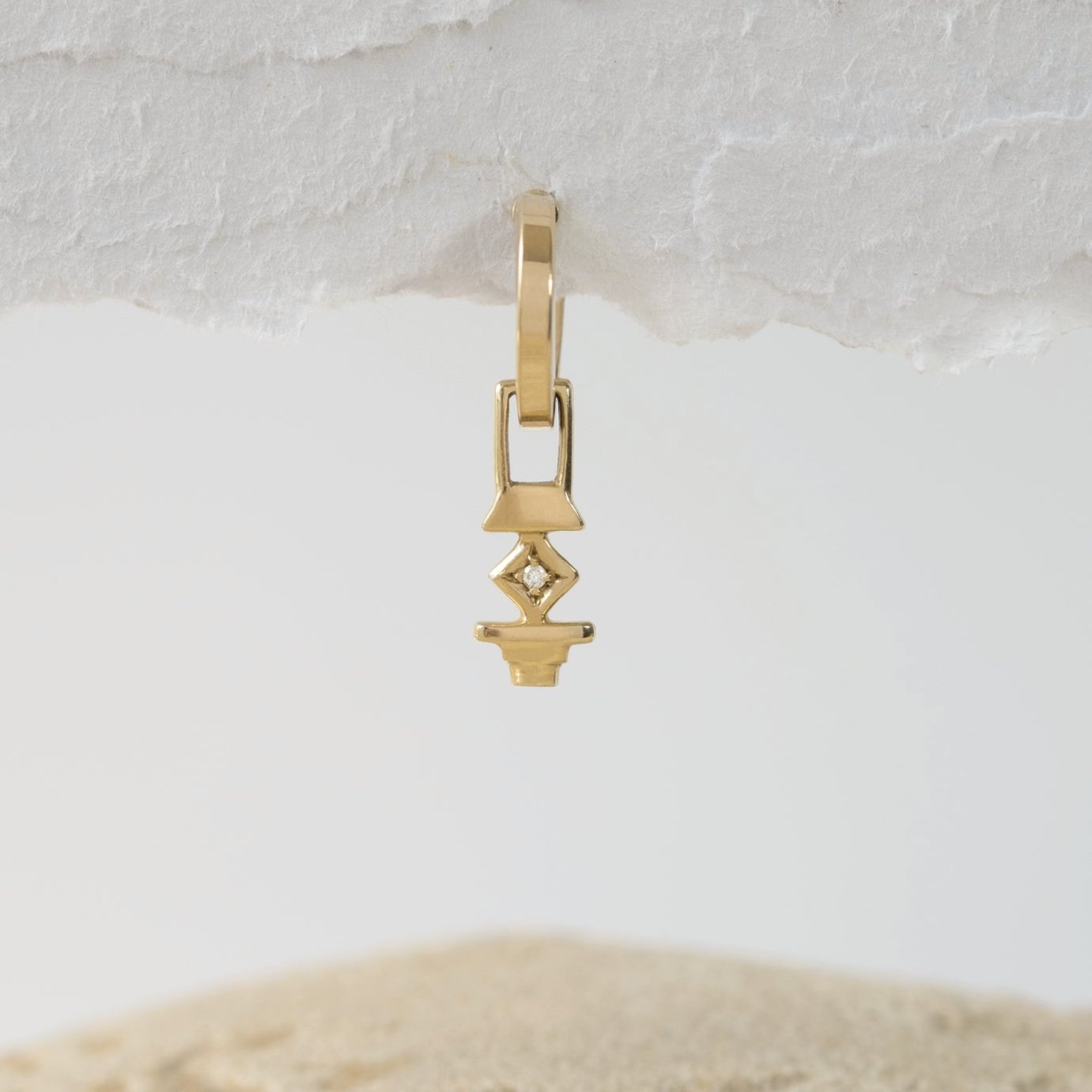 A photographer's hoop earring with a white diamond