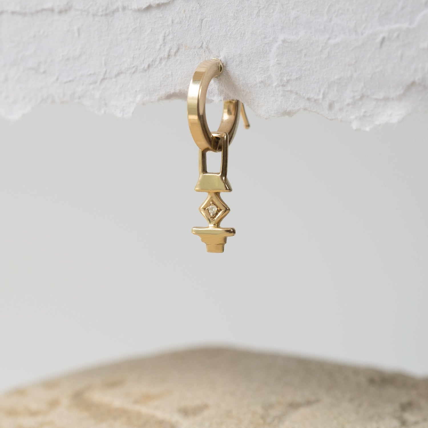 A photographer's hoop earring with a white diamond